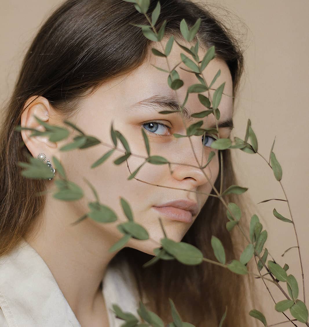 Girl with blue eyes and plant over her face
